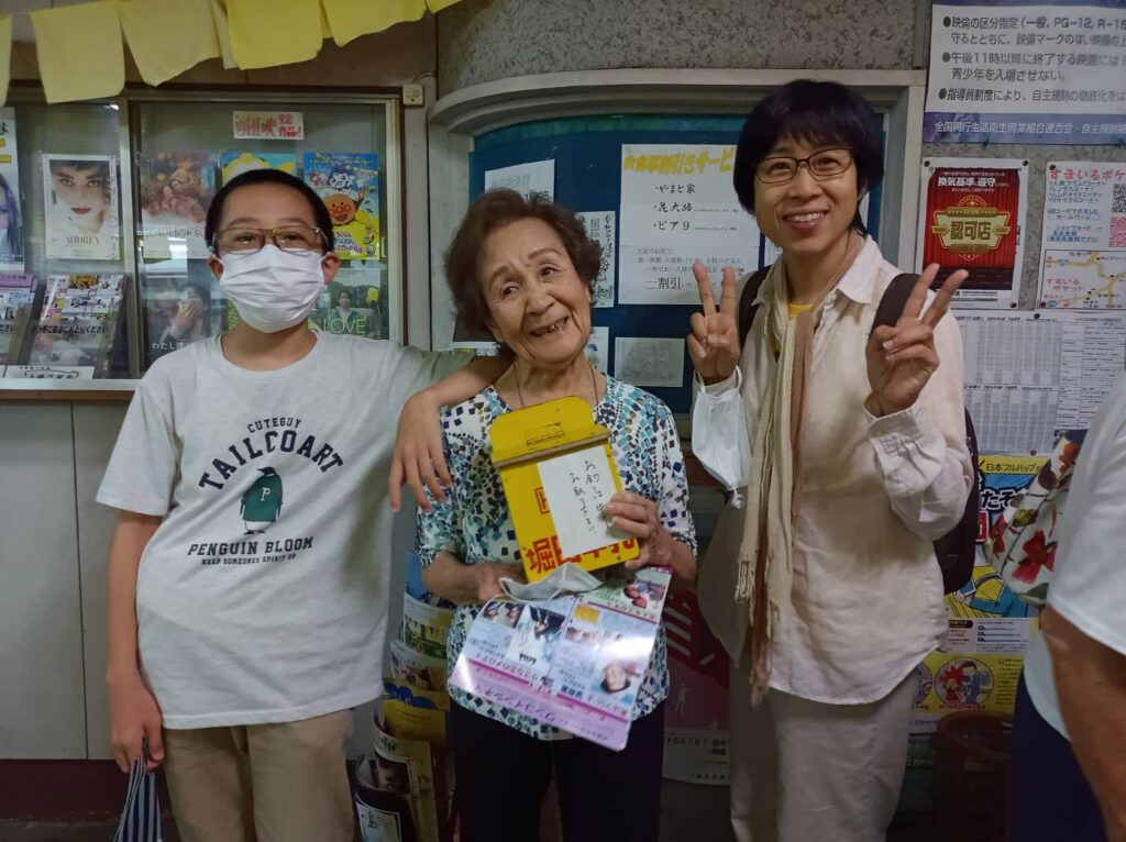 主人公の男が釣銭を盗んだ釣銭箱を手に‥